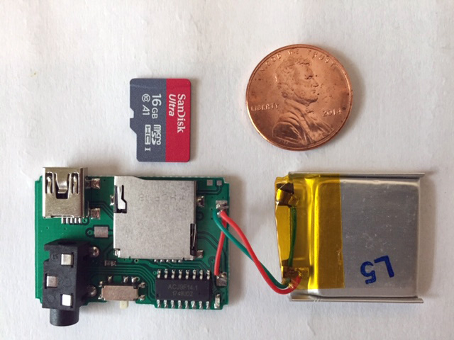 Small circuit board with microSD card, battery, and penny for size reference